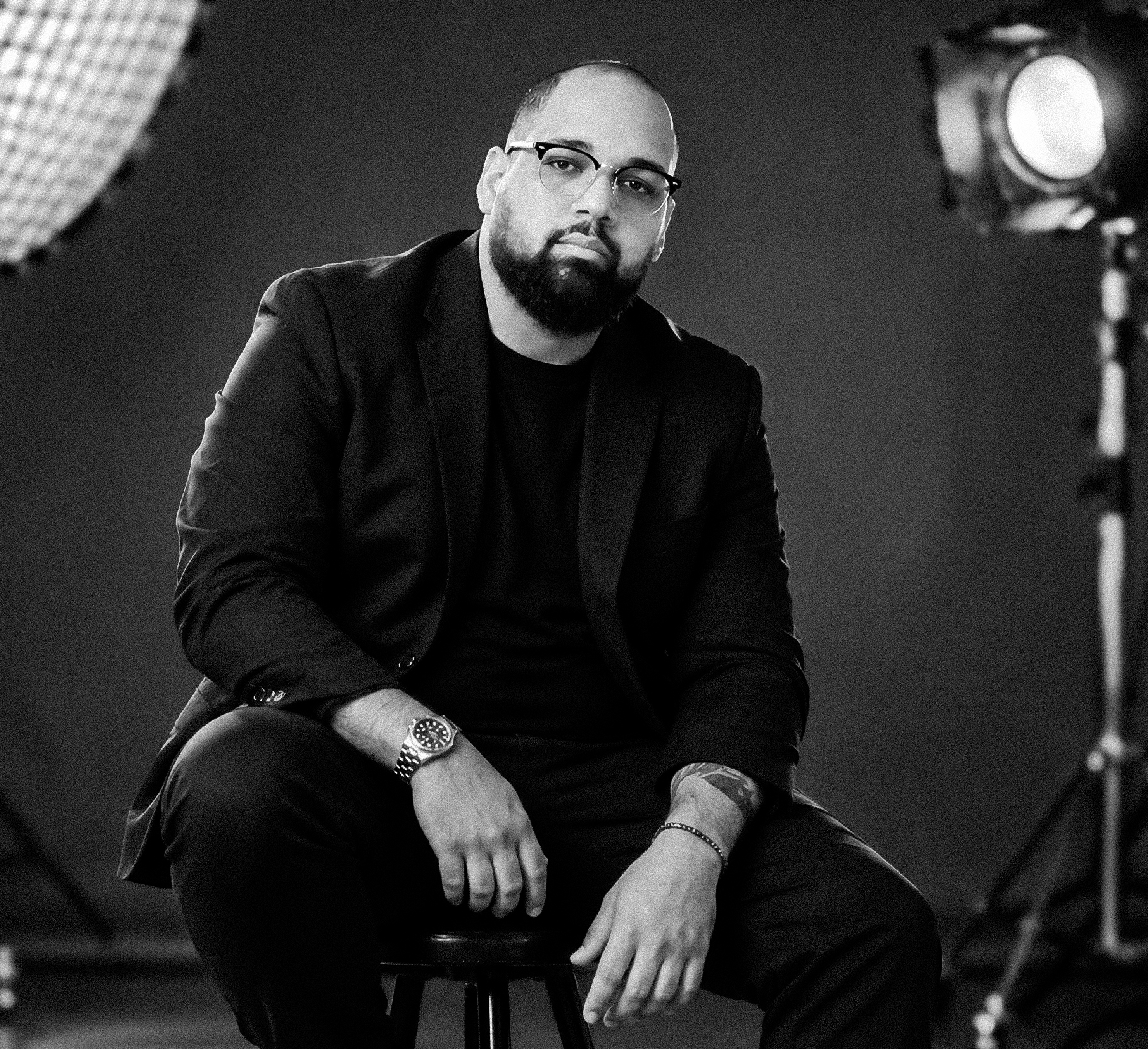Black-and-white studio portrait of photographer Yensy Marquez.